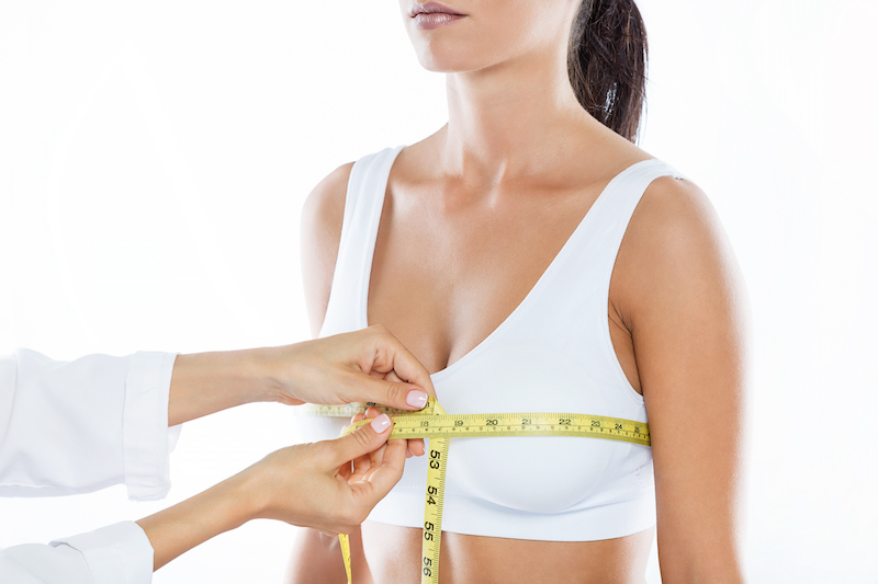 Breast Reduction image of womans breasts being measured. 